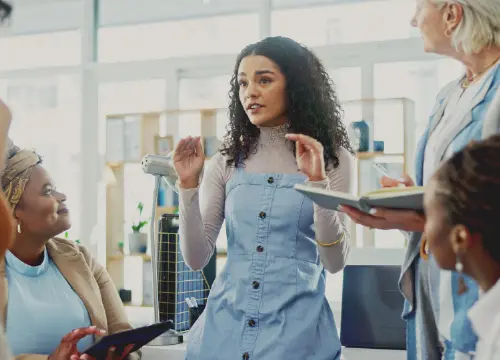 Employee talking to other employees as if giving a presentation.