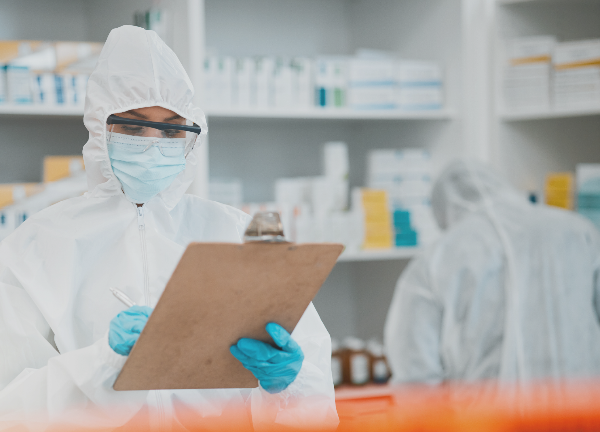A woman in a mask, hazmat suit and gloves holding a clipboard.