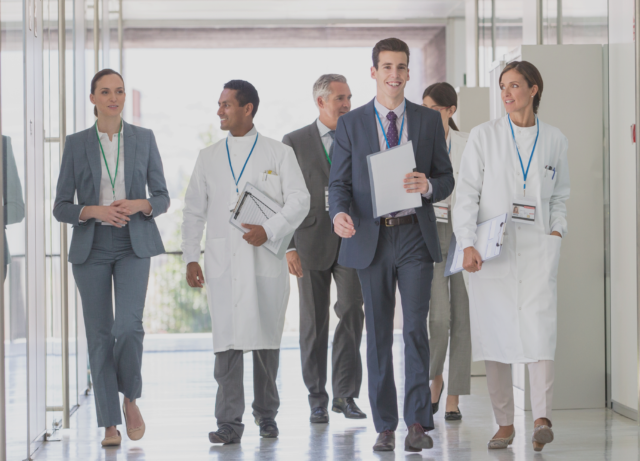 A group of medical personnel and doctors walking down a hallway.