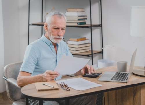 Aerospace worker looking at papers sitting at his desk.