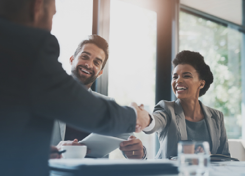 Three people having lunch and a man and woman shaking hands.