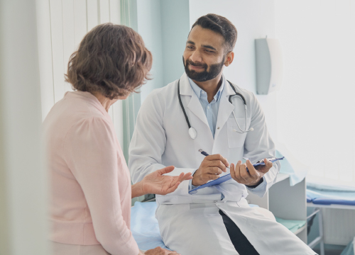 A doctor talking to a patient while he takes notes.