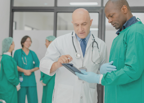 Life sciences doctors collaborating and looking at data on a tablet.