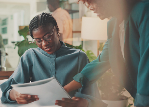 Woman in glasses talking to another woman for self assessment and certification assistant.