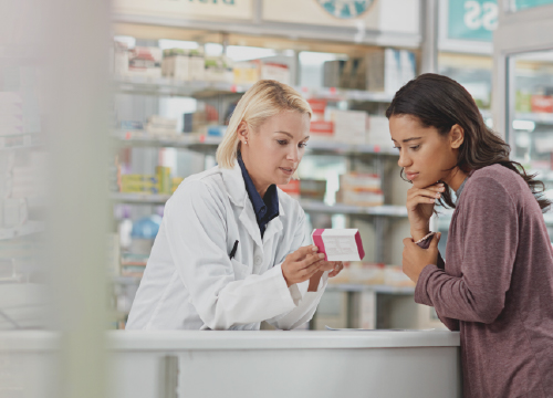 A pharmacist showing medication to a customer referencing EPCS.