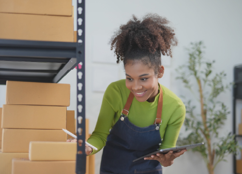 Smiling young woman looking at product stacked on a shelf.