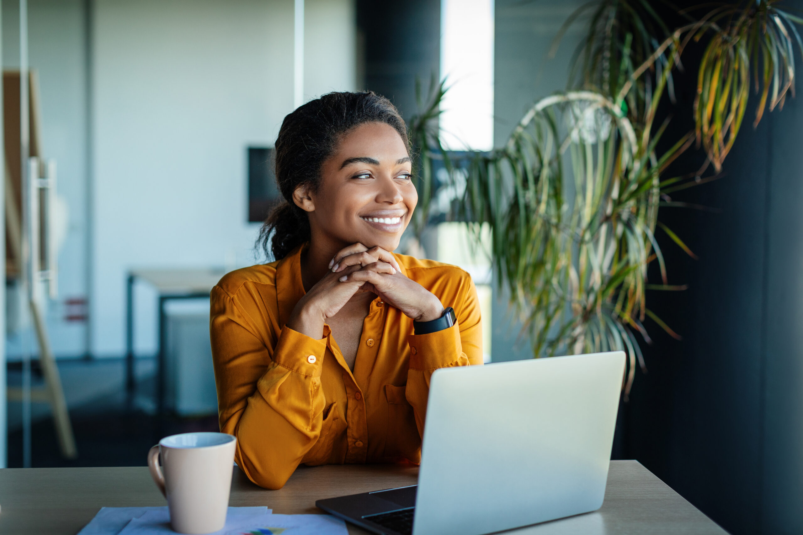 Woman working on laptop and smiling.